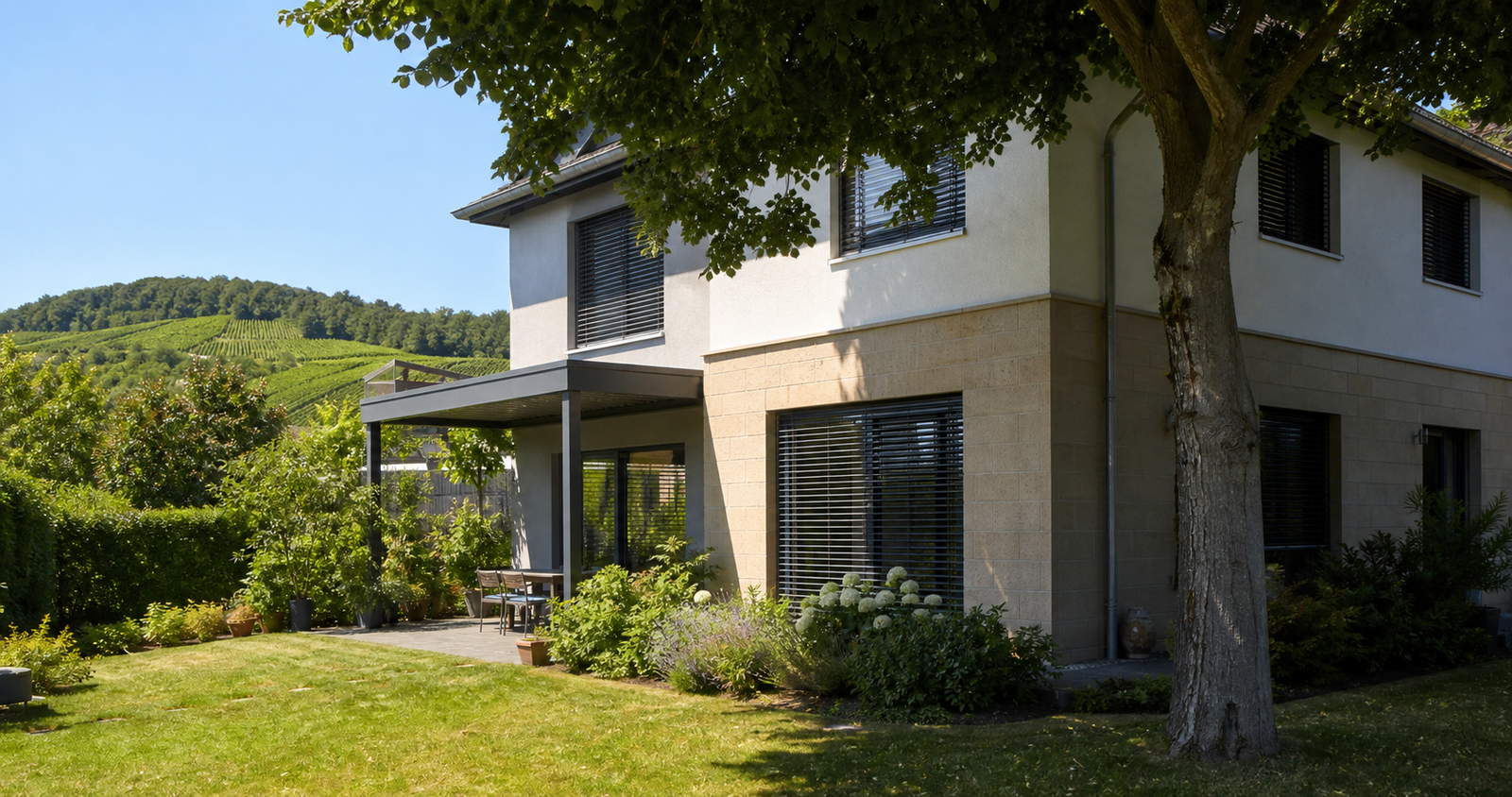 Wohnhaus in der Südpfalz mit außenliegenden Jalousien und schattenspendendem Baum als sommerlicher Hitzeschutz